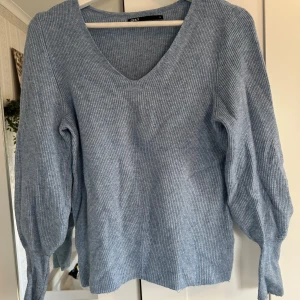 Ljusblå ribbad tröja från ONLY - Säljer en ljusblå ribbad tröja från ONLY med v-ringning och långa ärmar. Tröjan är mjuk och har en avslappnad passform, perfekt för lager-på-lager under kyligare dagar.