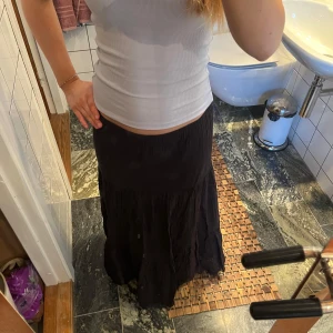 Svart långkjol från Gina Tricot - Säljer en svart långkjol från Gina Tricot. Kjolen har en flowy och luftig passform med resår i midjan, vilket gör den bekväm att bära. Perfekt att styla med en enkel topp eller stickad tröja.