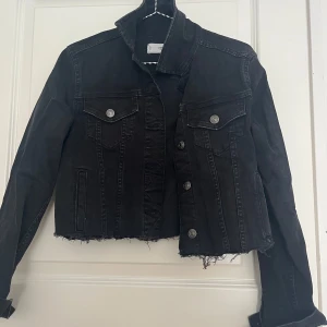 Svart jeansjacka  - Säljer en svart jeansjacka från mango Denim i croppad modell med rå kant nertill då den är klippt. Jackan har knappar framtill och två bröstfickor med lock. ☺️