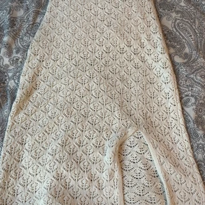 Vit virkad långkol - Säljer en vit virkad långkjol med vackert spetsmönster. Kjolen har en lång passform och är perfekt för sommarens tillfällen. Materialet är mjukt och luftigt, vilket gör den bekväm att bära under varma dagar. Storlek 134-140 i barnstorlek 