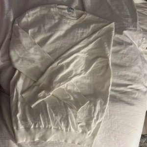 Vit tröja från Zara - Säljer en stilren vit tröja från Zara i storlek S. Tröjan har rund halsringning och långa ärmar, perfekt för en enkel och clean look. Passar till många olika outfits och är superenkel att matcha.