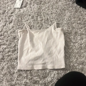 Vit ribbad croppad linnetopp - Den hr gått sönder så basen är knutna i början