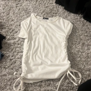 Vit ribbad topp med knyt i sidorna - Helt ny