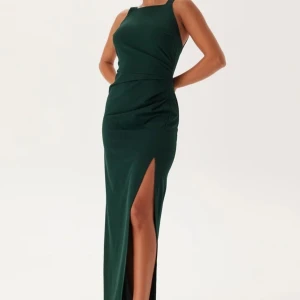 Mörkgrön långklänning med slits - Snygg mörkgrön balklänning med breda axelband, slits och djup rygg från Bubbleroom. Endast använd vid ett tillfälle, nyskick. 