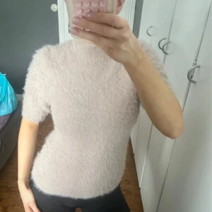 Beige fluffig tröja  - Supermjuk och fluffig beige tröja från Object med korta ärmar och rund hals. Perfekt för dig som vill ha en mysig och trendig look. Passar lika bra till jeans som till kjol.