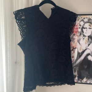 Svart spetsblus med volangärm - Supersnygg svart blus i spets med fin detaljer!! Det står storlek 36 men passar nog mer XS❤️