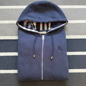 Marinblå hoodie från Burberry - Tjena! Säljer nu denna riktigt snygga Berburry zip tröjan. Extremt fint skick, endast använd 2 gånger. Storlek S, och färgen är marinblå. Vid frågor kontakta gärna! 