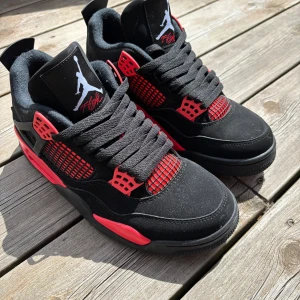 Nike Air Jordan 4 Black/Red sneakers - Snygga Nike Air Jordan 4 sneakers i svart och rött. Replika, oanvända i strl 40 men liten i storlek.