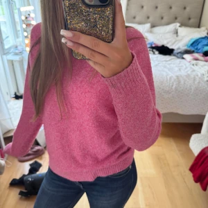 Rosa stickad tröja  - Supermysig rosa stickad tröja från Vero Moda med rund hals och ribbade muddar. Perfekt för lager-på-lager och chill dagar. Sitter lite loose och har långa ärmar. Passar dig som gillar färg och vill ha en enkel men snygg look.