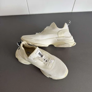 Vita sneakers från Steve Madden - Snygga chunky sneakers från Steve Madden i helvitt med mesh-ovandel och coola detaljer. Skorna har tjock sula, snörning och svartvit logga på plösen och hälen. Perfekta för dig som gillar sportig och trendig stil. Använd en gång 