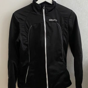 Träningskofta - Snygg svart träningskofta från Craft. Passar att ha ute i alla väder. Storlek M men passar även L