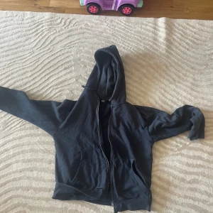 Mörkblå hoodie med dragkedja - mörkbå hoodie med hel dragkedja och huva. Klassisk modell med känguruficka framtill och långa ärmar. Perfekt för chill dagar eller när du vill ha en enkel och stilren look. Mjuk och skön, troligtvis i bomull eller bomullsblandning.