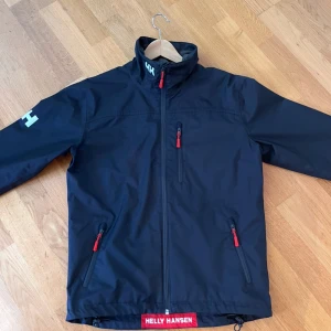 Helly Hansen vindjacka - Snygg marinblå vindjacka från Helly Hansen, storlek S, skick 10/10  Perfekt för kyliga sommarkvällar och en stilren look. (Pris kan diskuteras)