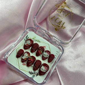 CherryKitty(L);Short Almond - Snygga röda gelé lösnaglar med glittereffekt och 3D-design. Några naglar har söta Hello Kitty-motiv och körsbärsdetaljer, andra har vita linjer. Kommer i storlek L: 17 mm, 12,5 mm, 13 mm, 12 mm, 10 mm . Perfekt för dig som vill ha en unik och lekfull look.
