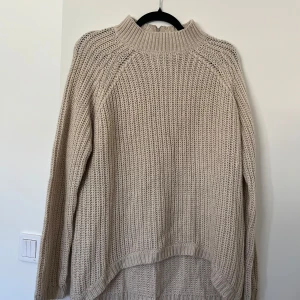 Beige stickad tröja - Säljer en beige stickad tröja med half zip och hög krage.