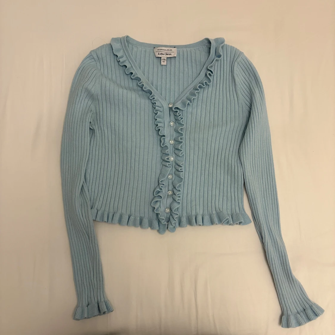 Ljusblå ribbad kofta med volang - 1