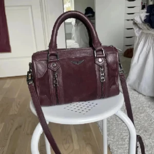 INTRESSKOLL! - Cool vinröd handväska från Zadig Voltaire, axelband förekommer och väskan har inga defekter. En jättesnygg väska inför sommaren som är väldigt efterlängtad! Den passar bra till alla outfits med alla olika stilar. (Består av äkta mocka) Buda gärna!❤️❤️