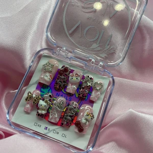 KittyKlawz (S);Medium Square - Supergulliga y2k gelé press-on naglar i rosa med Hello Kitty-tema, leopardmönster och 3D-dekorationer som stjärnor, hjärtan och rosetter. Dekorerade med pärlor och strass. Perfekt för dig som älskar unika och kreativa naglar med extra bling. I storlek S: 15 mm, 11,5 mm, 12 mm, 11 mm, 9 mm 