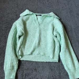 Mintgrön stickad tröja Gina Tricot - Superfin mintgrön stickad tröja från Gina Tricot i ribbat material. Tröjan har en snygg krage och v-ringning, samt långa ärmar och en något croppad passform. Perfekt för lager-på-lager och att lyfta din outfit med en fräsch färg.💞