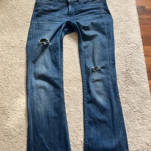Jätte snygga lee jeans - Blåa jeans ifrån lee, de är lite slitna där nere eftersom de är för långa för mig. I midjan är de storlek 28 och på längden är de storlek 33. Kolla sista bilden för att se hålen vid fötterna, jag är 160 för referens, fråga om ni kan sänka priset, jag sänker gärna men inte för mycket eftersom de va ganska dyra när jag köpte dem.