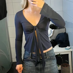 Mörkblå knyttröja - Säljer denna fina mörkblå tröjan som lämnar det öppet vid magen. Den har två band som man kan låta hänga eller knyta en fin rosett med. Nypris:399kr Nyskick💗🫶🏻