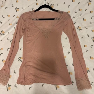 Rosa intimissimi tröja  - Supersöt ljusrosa långärmad topp från Intimissimi med v-ringning och fina spetsdetaljer vid halsringning och ärmslut. Inga defekter på den, då den bara e testad. Säljs inte längre. 