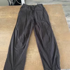Svarta cargopants från Zara med snörning - Svarta cargopants från Zara med elastisk passform med snören vid midjan och bensluten. Aldrig använda, men lappen har lossnat från ”snöret”