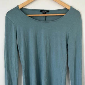 Blå långärmad tröja från Amisu - Enkel och stilren blå långärmad tröja från Amisu. Tröjan har rund halsringning och är tillverkad i ett mjukt och lätt material som känns skönt mot huden. Perfekt att matcha med jeans eller kjol för en avslappnad look.