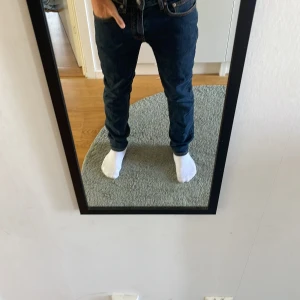 Mörkblå jeans från Dressmann  - Säljer ett par mörkblå jeans från Dressmann i klassisk modell med fem fickor och snygga kontrastsömmar. Jeansen är slim men inte för tajta. Perfekta för dig som gillar en enkel och stilren look.