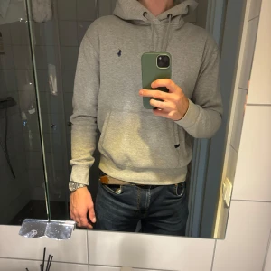 Ralph Lauren hoodie – ljusgrå, strl M - Supersnygg hoodie i klassisk ljusgrå färg från Ralph Lauren. Använd några gånger men i grymt fint skick – skulle säga 9/10! Tyvärr växt ur den.