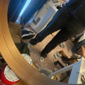 Svarta kostymbyxor med rak passform - Säljer ett par svarta kostymbyxor med klassisk rak passform och bälteshällor. Byxorna har sidofickor och bakfickor med knapp. Perfekta för en clean och stilren look. Materialet känns mjukt och lätt, troligen bomull eller polyester.