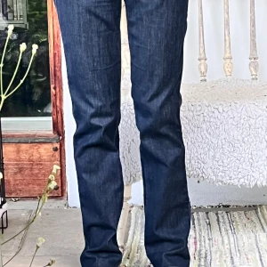 Lee mörkblå jeans W27 L31 - Mörkblå Lee jeans i modellen Marion Straight med klassisk rak passform. Jeansen har fem fickor, normal midja och är tillverkade i ett slitstarkt denimtyg. Perfekta för dig som gillar en tidlös och clean look.