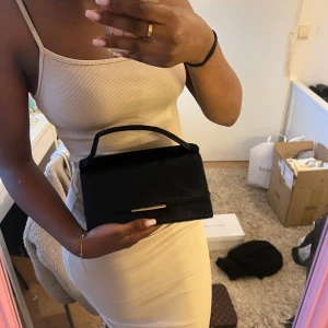 Svart handväska från H&M med gulddetalj - Onesize 