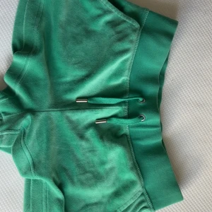 Super sköna Gröna Juicy Couture shorts - Snygga gröna shorts från Juicy Couture i mjuk frotté med bred resår och snörning i midjan. Klassisk logga broderad på benet och silverdetaljer på snöret. Perfekta för chill eller träning, riktigt sköna och trendiga.💚