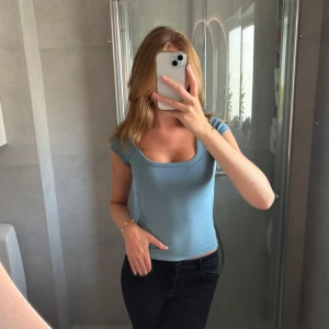 Blå/Turkos topp - Blå/Turkos topp eller tshirt från Bershka. Ribbad i tyget ochlite djupare uringning. Använd 1 gång. Storlek S🥰🥰