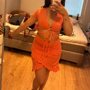 Korallfärgad klänning - Superfin korallfärgad klänning, den ser mer orange ut på bilden än vad den är i verkligheten, det är en jättefin korallfärg. Storlek Xs/S