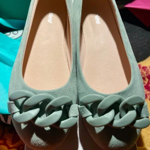 Mintgröna ballerinaskor från Graceland i stl 36,5/37 - Bara provade. Sitter bäst på 36,5/liten 37. Snygga mintgröna ballerinaskor från Graceland i mockaimitation. Skorna har en rund tå och är dekorerade med en chunky kedjedetalj framtill. Perfekta för dig som vill ha en stilren men trendig look. Butiken impregnerade de vid köpet. 