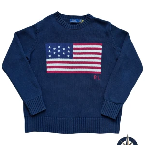 Polo Ralph Lauren USA Tröja - Premium stickad tröja med ikonisk USA-flagga av Polo Ralph Lauren. - Storlek: M - Skick: Mycket bra, sparsamt använd. - Alla plagg från NordFinds är noggrant kontrollerade för att garantera 100% äkthet.