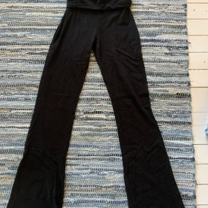 Svarta bootcut byxor Gina Tricot XXS - Svarta bootcut byxor från Gina Tricot i mjukt stretchigt material. Utsvängda ben ger en snygg siluett. Perfekta för dig som gillar en stilren look med lite edge.