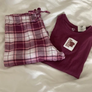 Mörklila pyjamas från cubus strl 158/164 - Rutiga pyjamasbyxor med tillhörande tshirt. Som är använda endast 1 gång. 