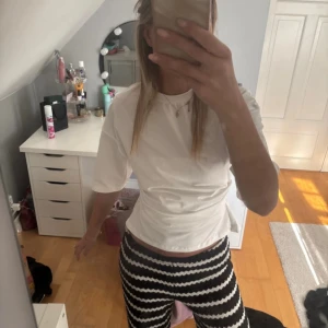 Vit croppad t-shirt med loose fit - Säljer en vit t-shirt med croppad passform och loose fit. T-shirten har rund hals och korta ärmar, perfekt för dig som gillar enkel och clean stil. Materialet känns som bomull och är mjukt mot huden. Passar dig som vill ha en chill och stilren look.
