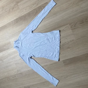 Ljusblå ribbad polotröja Esmara - Supersnygg ljusblå polotröja från Esmara i ribbad bomullsmix. Tröjan har lång ärm och tight passform, perfekt att styla med jeans eller kjol. Enkel och stilren design med hög krage som ger en clean look.