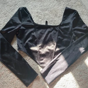 Svart långärmad topp H&M Divided - Snygg svart korsettinspirerad topp från H&M Divided i storlek M. 