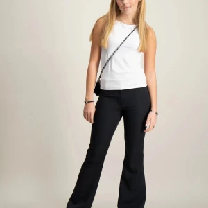 Svarta bootcut/flare kostymbyxor - Snygga svarta kostymbyxor med bootcut-snitt och medel till låg midja. Byxorna har pressveck, hällor för bälte och två fuskfickor bak. Perfekta för en clean och stilren look. Materialet är slätt och känns dressat. Aldrig använda, bara provat. Passar mig perfekt som är 162 cm 💕