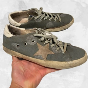 Golden Goose skor gråa - •Golden Goose Superstar Sneakers gråa. Skick: 7-8/10. Finns synliga tecken på användning men har tagits väl hand om! Givetvis äkta. Original påse & box medföljer (OBS, Boxen är skadad!) storlek 40 men som GGDB’s är så är dom stora i storlek dvs 40-41 i storlek skulle ja säga dom motsvarar. hör av dig vid frågor eller funderingar, mvh Oliver🙂