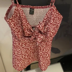 Rosa blommigt linne - Säljer nu mitt rosa blommiga topp då jag inte kommer till att använda den💕 använd en sommar ett fåtal gånger i fint skick med knyte fram till💕  Storlek 34💕