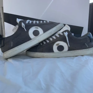Grå sneakers från Oliver Cabell - Snygga grå sneakers från Oliver Cabell med vit sula och vita detaljer. Skorna är tillverkade i Italien och har en stilren design med snörning. Perfekta för en avslappnad stil. Skorna är ju inte helt nya men funkar bra och är ändå i bra kvalité skriv till mig om fler bilder eller vid intresse. Obs inget og men här köpes bevis som kan skickas med vid köp om man vill ha de