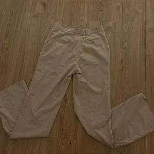 Beige kostymbyxor från Hennes Collection - Jag säljer beige kostymbyxor från Hennes Collection. De är knappt använda och de har väldigt bra skick! Storlek S highwaist/midwaist. 