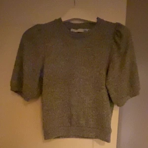 Grå tröja med puffärmar - Säljer en stilren grå tröja med puffärmar. Tröjan har en rund halsringning och är tillverkad i ett mjukt material som ger en bekväm passform. Perfekt för en avslappnad look.