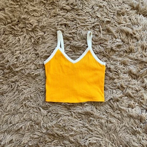Gul ribbad linnetopp - Säljer en solgul ribbad linnetopp med vita kanter. 